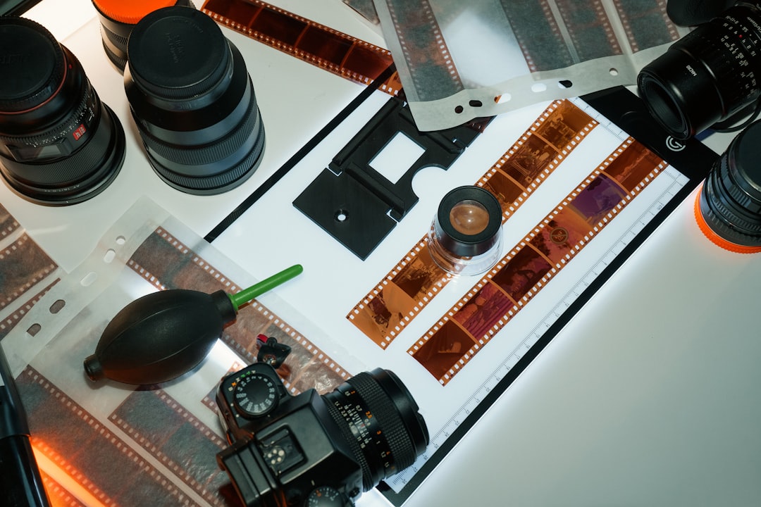 Camera lenses, film strips, and photography equipment laid out.